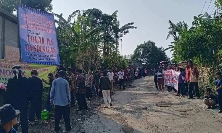 Masyarakat desa Kutamekar turun ke jalan melakukan pemasangan spanduk penolakan As Bendungan. 