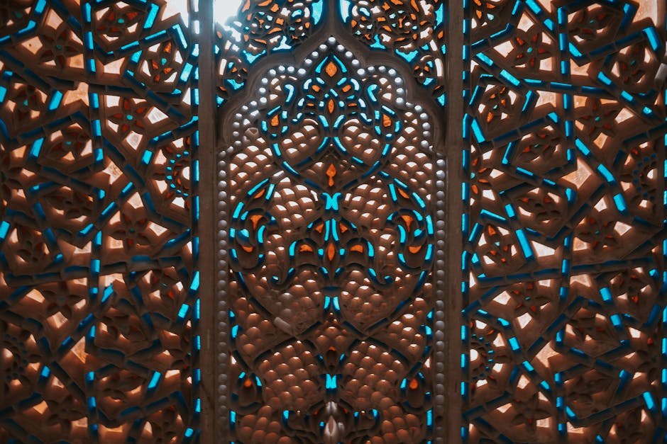 Deskripsi gambar dalam Bahasa Indonesia: Foto sebuah naskah klasik kitab hadis yang terbuka di atas meja kayu tua dengan pencahayaan hangat di dalam sebuah perpustakaan Islam tradisional yang dipenuhi rak buku kitab kuning.