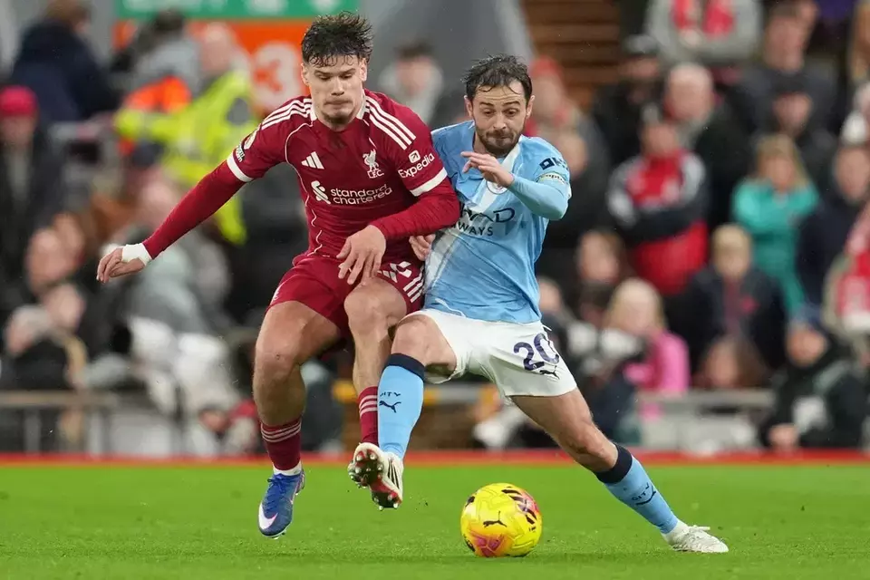 Pemain Liverpool, Milos Kerkez (kiri), berduel memperebutkan bola dengan gelandang Manchester City, Bernardo Silva, pada laga Premier League di Stadion Anfield pada Minggu 8 Februari 2026. (AP/Jon Super)