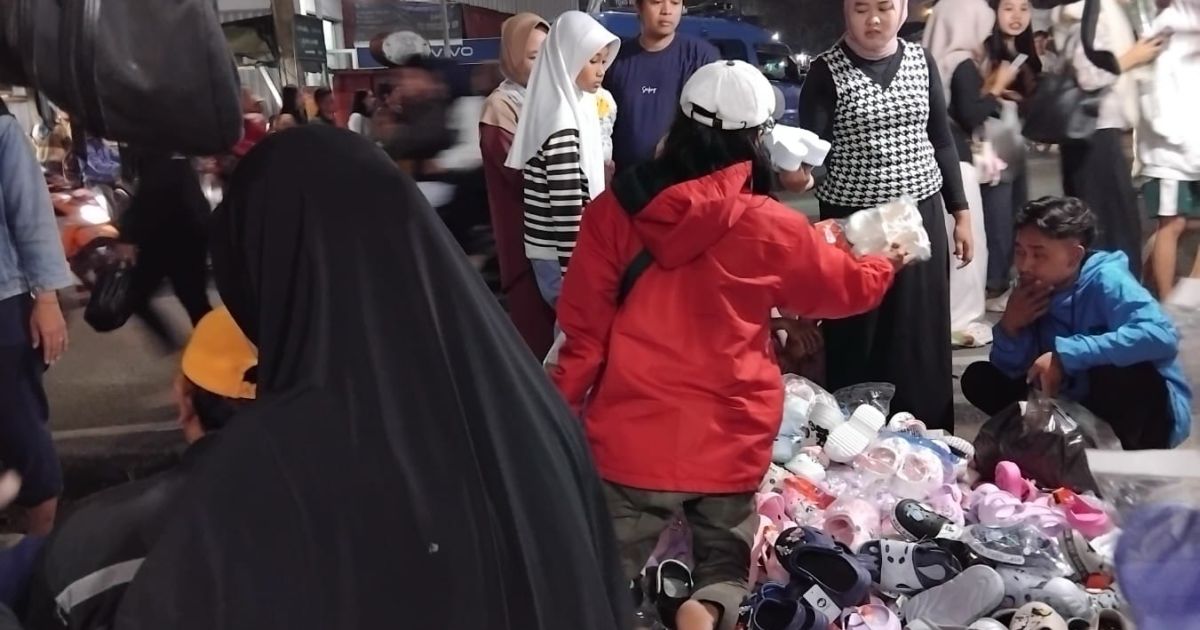 Pedagang sandal musiman menunggu pembeli di lapaknya jelang Idul Fitri. Perbedaan waktu Lebaran tahun ini membuat omzet penjualan menurun dibandingkan tahun sebelumnya. ( Dede)