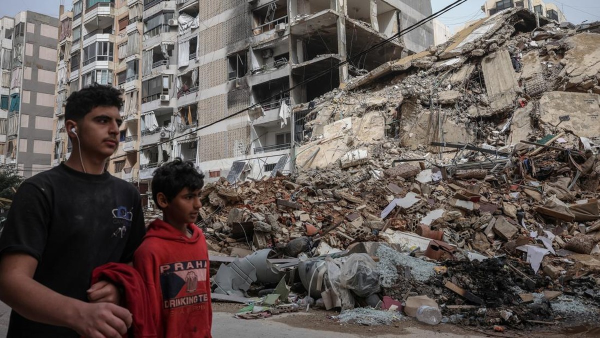 Foto: Orang-orang berjalan melewati bangunan yang hancur, setelah gencatan senjata selama 10 hari antara Lebanon dan Israel mulai berlaku, di pinggiran selatan Beirut, Lebanon, 18 April 2026. (REUTERS/Marko Djurica)
