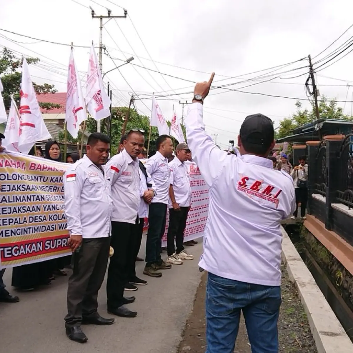 buruh melakukan aksi unjuk rasa damai membawa bendera (Foto: Borneoinfonews)