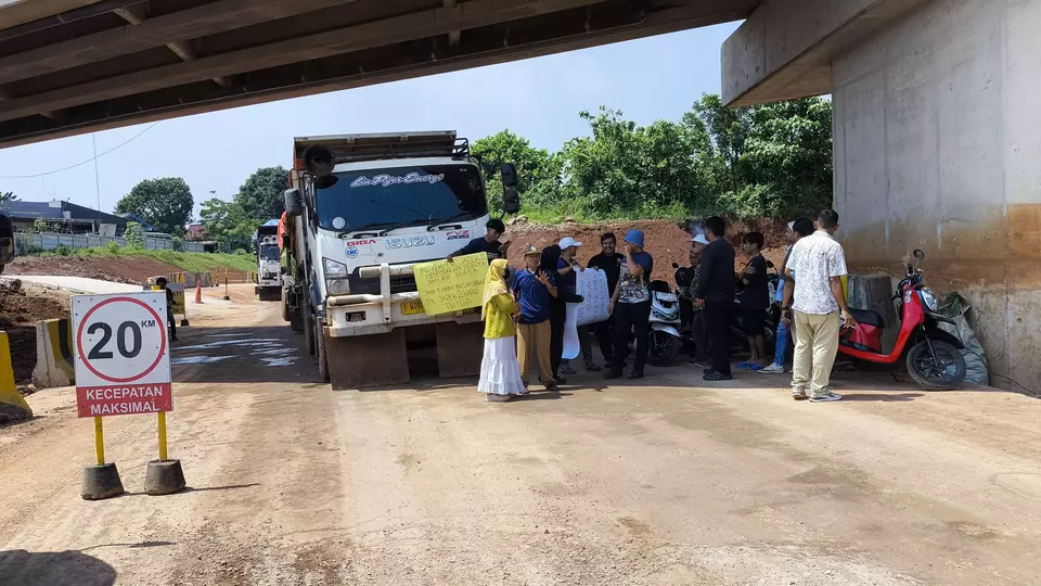 Sejumlah warga menghentikan aktivitas truk pengangkut tanah dalam proyek pembangunan Tol Jakarta-Cikampek (Japek) 2 Selatan di Desa Kertarahayu, Kecamatan Setu, Kabupaten Bekasi, Senin 27 April 2026. (Beritasatu.com/Eka Jaya Saputra)
