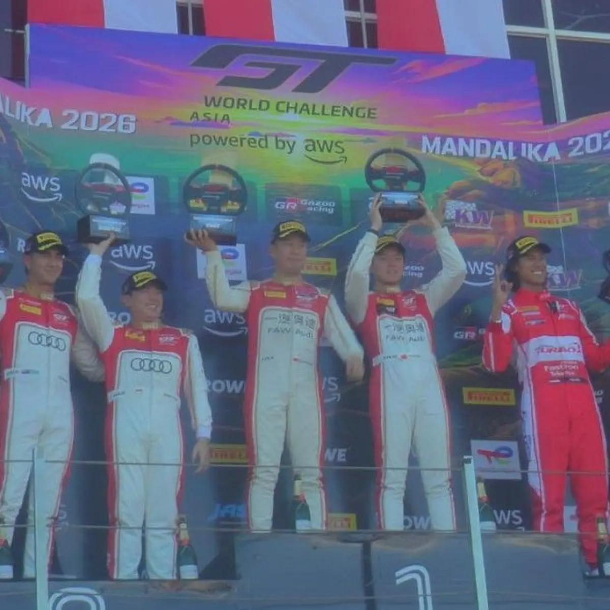 Sean Gelael (kostum merah) saat naik podium race 1 GT World Challenge Asia 2026 Mandalika, Sabtu (2/5/2026). (Foto: Edi Suryansyah/detikBali)