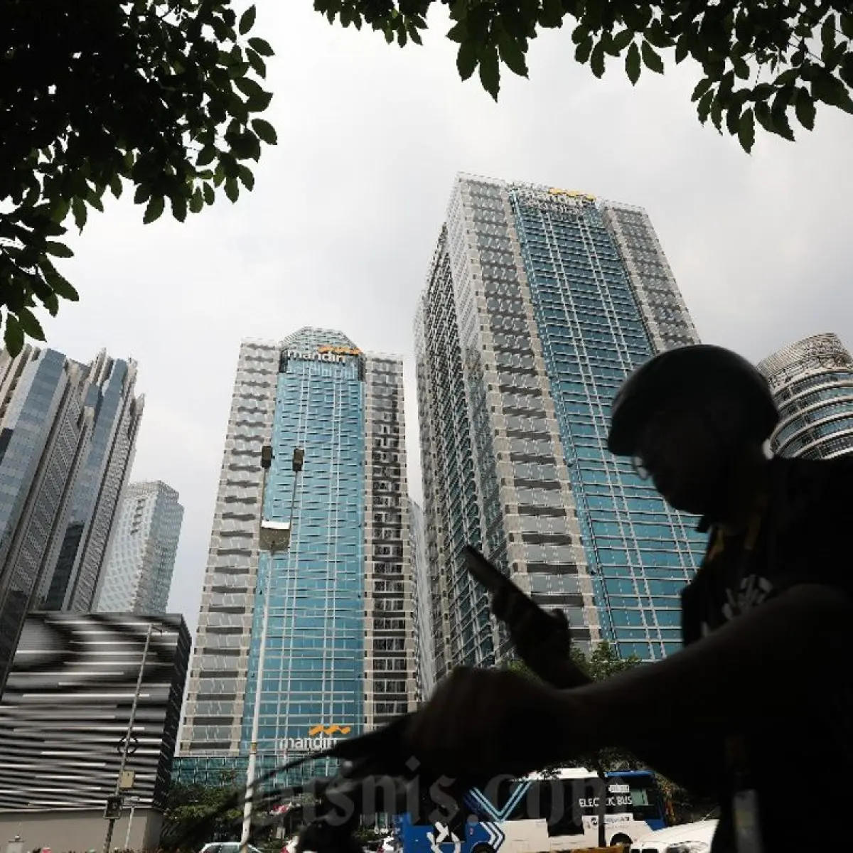 Warga melintas di dekat gedung Kantor Pusat Bank Mandiri atau Menara Mandiri di Jalan Jenderal Sudirman, Jakarta, Selasa (5/7/2025). PT Bank Mandiri (Persero) Tbk. melakukan pemindahan alamat kantor pusat ke Menara Mandiri dari sebelumnya di Wisma Mandiri