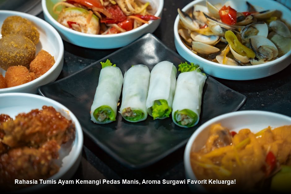 Sepiring Tumis Ayam Kemangi yang mengkilap dengan warna merah kecoklatan, ditaburi daun kemangi hijau segar sebagai hiasan kontras.