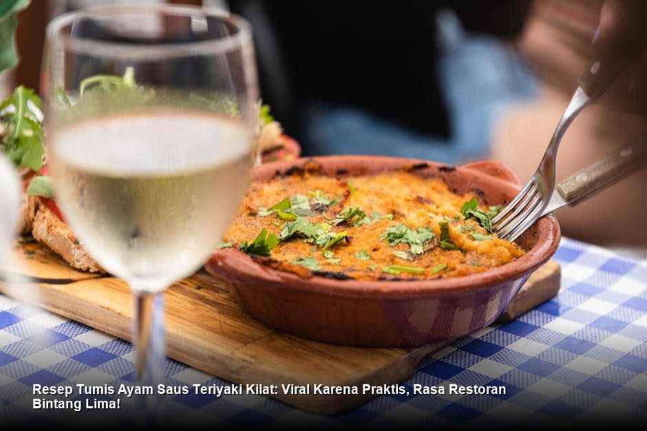 Sepiring penuh Tumis Ayam Saus Teriyaki mengkilap dengan taburan wijen, disajikan bersama nasi putih hangat dan irisan daun bawang segar.