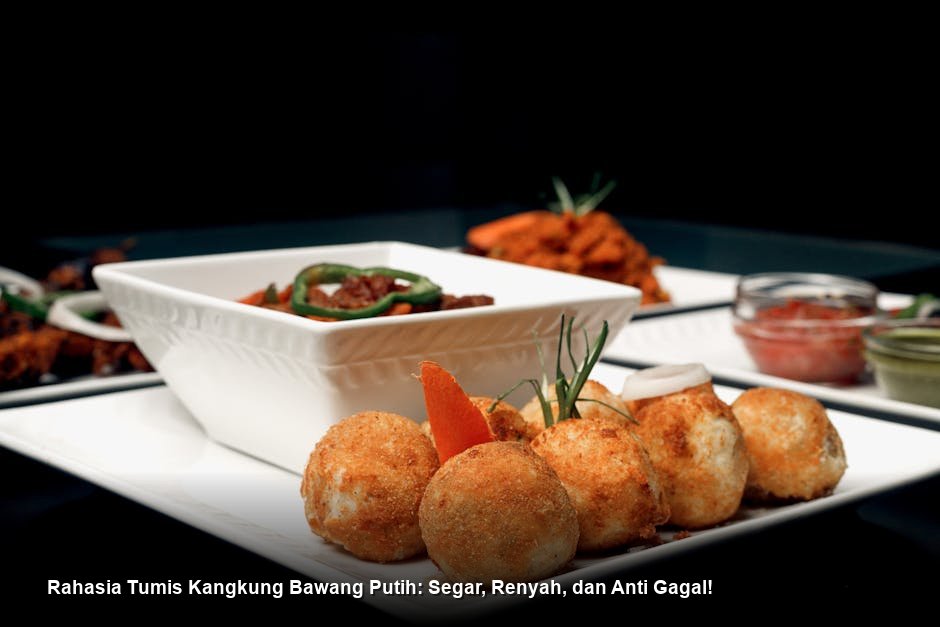 Semangkuk Tumis Kangkung Bawang Putih yang baru matang, menampilkan warna hijau cerah kontras dengan irisan bawang putih keemasan, disajikan di atas piring keramik putih.