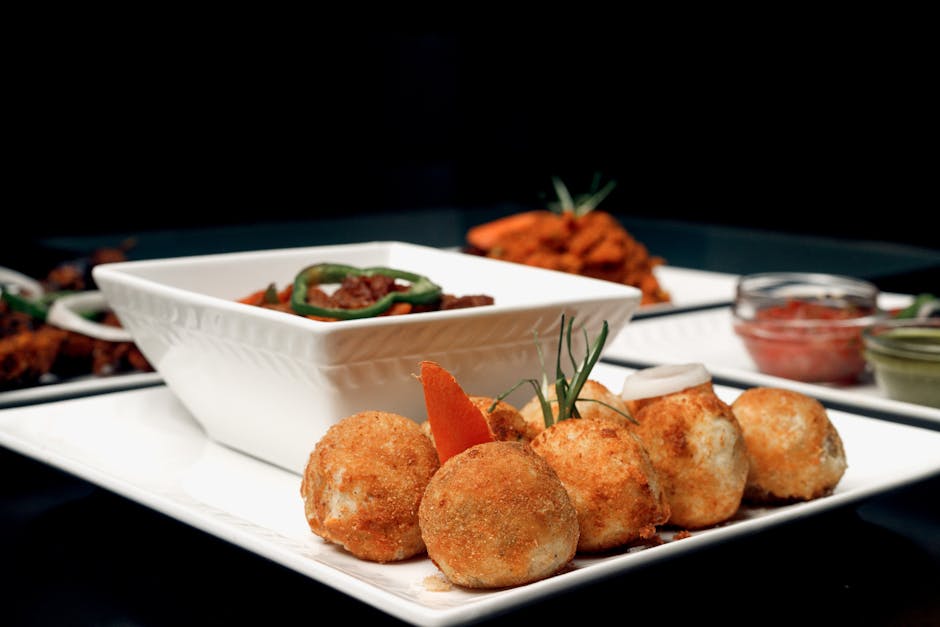 Sepiring ayam kecap mentega yang berkilau kecokelatan dengan taburan bawang goreng dan irisan daun bawang yang segar di atas piring keramik putih.