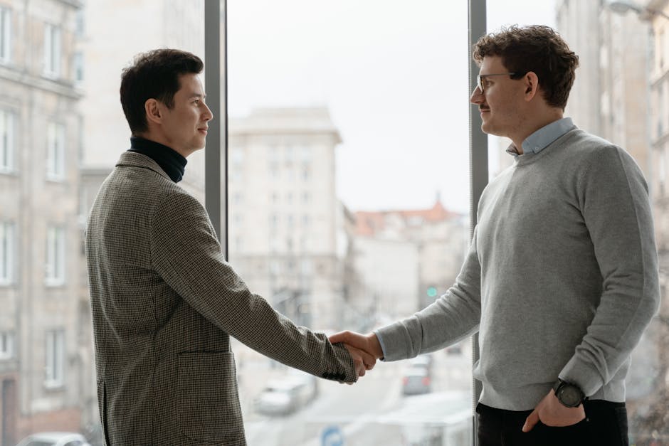 Seorang profesional sedang menutup laptopnya di rumah sambil tersenyum ke arah pasangannya, menunjukkan keberhasilan dalam menetapkan batas kerja yang sehat.