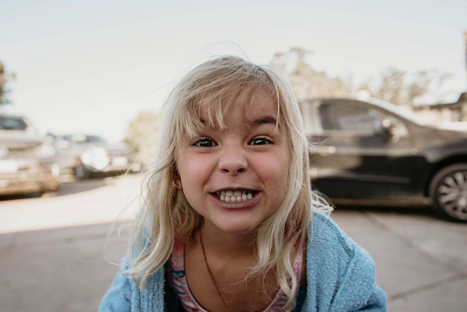 Sebuah mobil modern yang sedang melaju di jalan raya dengan visualisasi grafis sensor keselamatan yang sedang aktif.