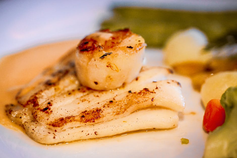 Sepiring ayam bakar kecap yang berkilau kecokelatan dengan taburan bawang goreng dan lalapan segar di sampingnya.