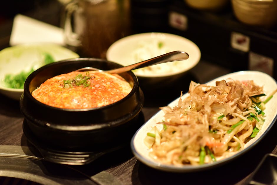 Potongan ayam kecap yang berkilau kecokelatan dengan saus kental yang menggoda, dihiasi irisan daun bawang dan bawang bombay di atas piring putih estetik.