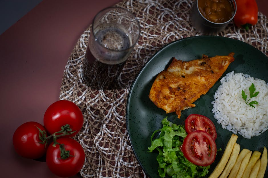 Sepiring ayam kecap mentega yang berkilau kecokelatan dengan karamelisasi saus yang cantik, dihiasi irisan bawang bombay dan daun bawang segar di atas piring putih estetik.