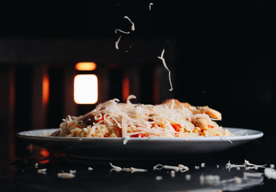 Seorang koki sedang mengukus berbagai sayuran segar berwarna-warni di dalam dapur yang bersih dan modern.