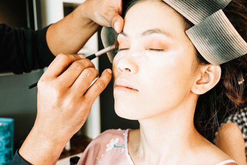 Seorang wanita sedang mengaplikasikan tabir surya di wajahnya di bawah sinar matahari pagi, melambangkan pentingnya perlindungan kulit harian.