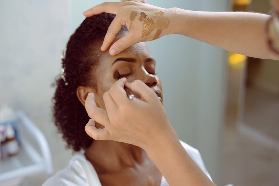 Seorang wanita sedang mengaplikasikan produk perawatan kulit di wajahnya di pagi hari, menekankan rutinitas harian yang penting.